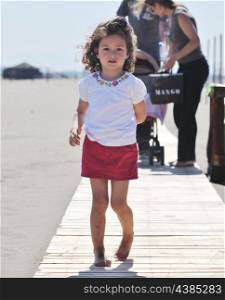 little girl have fun and play on the beach