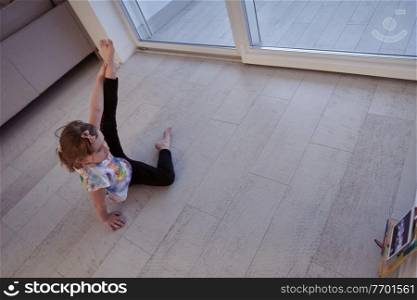 Little girl have online training over  tablet and doing modern ballet dance exercise at home. Online education concept class in modern ballet school. Social distance during quarantine, self-isolation in coronavirus