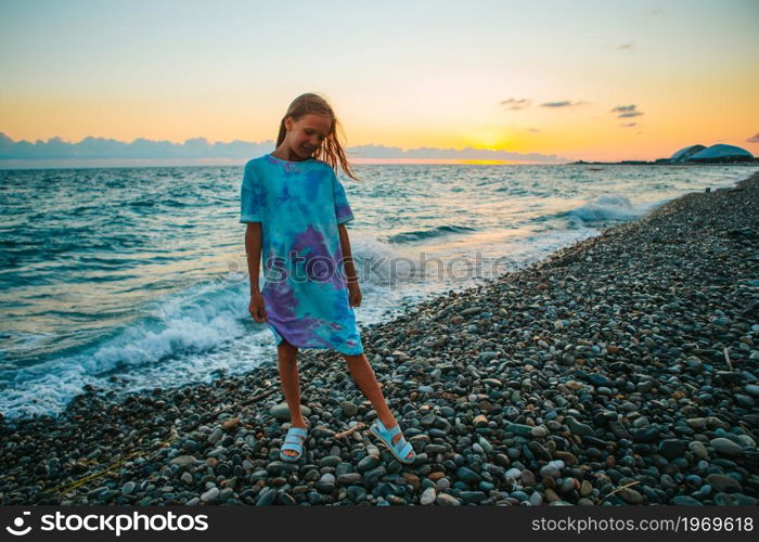 Little girl having fun at tropical beach during summer vacation. Little happy funny girl have a lot of fun at tropical beach playing together