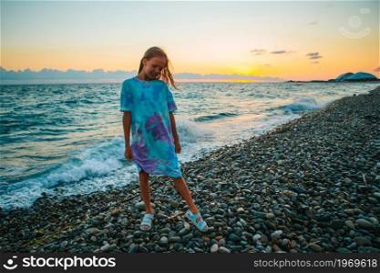 Little girl having fun at tropical beach during summer vacation. Little happy funny girl have a lot of fun at tropical beach playing together