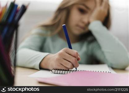 little girl having headache while doing her homework