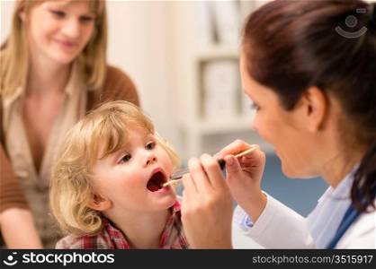 Little girl having throat examination by pediatrician using light pen