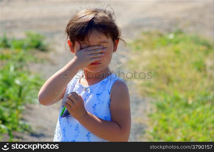 Little girl hiding, to cover eye, to cover one?s face with one?s hands&#xD;