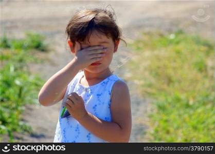 Little girl hiding, to cover eye, to cover one?s face with one?s hands&#xD;