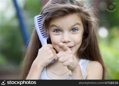 Little girl holding a comb in his hand