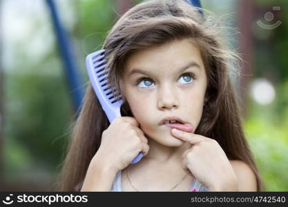 Little girl holding a comb in his hand