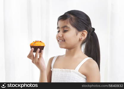 Little girl holding a cupcake