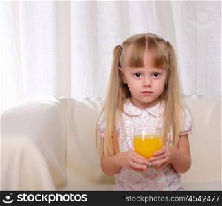 Little girl holding a glass of orange juice