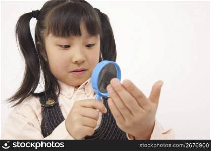 little girl holding a magnifying glass