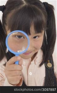 little girl holding a magnifying glass