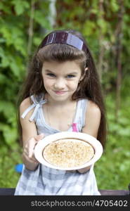 little girl holding a plate with a white currants