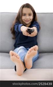 Little girl holding a TV remote control