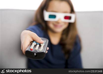 Little girl holding a TV remote control and wearing 3d glasses