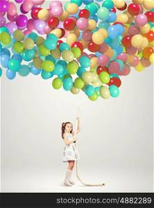 Little girl holding balloons. Image of little girl holding bunch of colorful balloons