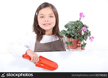 Little girl holding plant pot and trowel