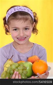 Little girl holding plate of fruit