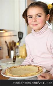 Little girl holding plate of pancakes