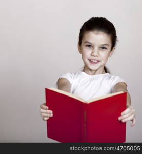 Little girl holding red book, studio on white background