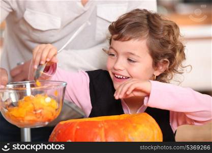 Little girl hollowing out a pumpkin