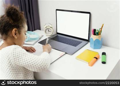 little girl home during online school using laptop