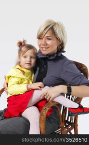 little girl hugs the young mother on the white background