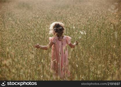 little girl in a wheat field. little girl with a bouquet of wheat in the sunlight. outdoor shot.. little girl in a wheat field. little girl with a bouquet of wheat in the sunlight. outdoor shot