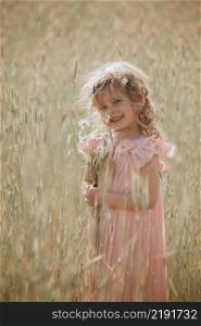 little girl in a wheat field. little girl with a bouquet of wheat in the sunlight. outdoor shot.. little girl in a wheat field. little girl with a bouquet of wheat in the sunlight. outdoor shot