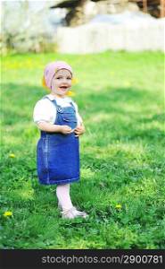 little girl in blue dress walks across grass