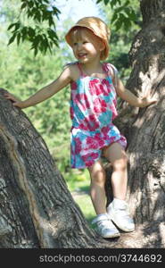 Little girl in colored dress on a large branching tree