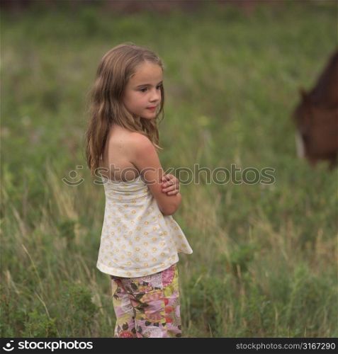 Little girl in field with a horse
