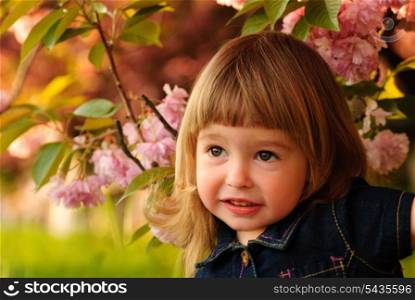 Little girl in garden, under the sakura tree.