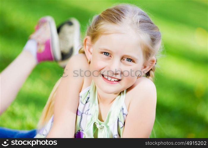 Little girl in park. Image of little cute girl lying on grass in park