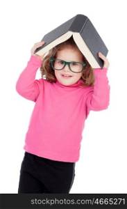 Little girl in pink with glasses and a book on her head isolated on a white background