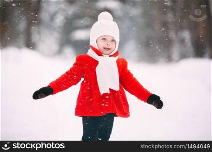 Little girl in red coat with a teddy bear having fun on winter day. girl playing in the snow.. Little girl in red coat with a teddy bear having fun on winter day. girl playing in the snow