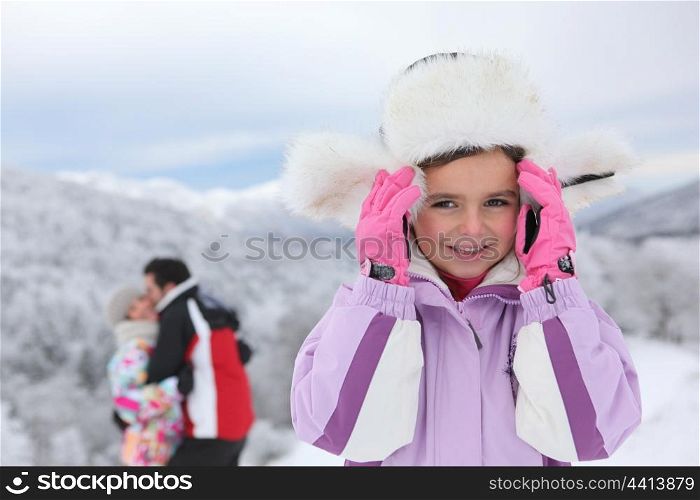 Little girl in snow near parents