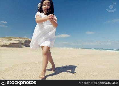 Little girl in the beach holding and playing with stones