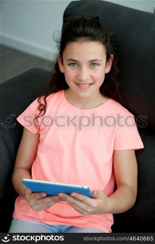 Little girl in the sofa at home with a tablet