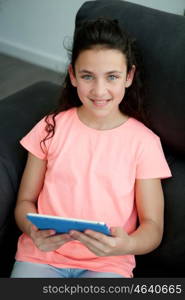 Little girl in the sofa at home with a tablet