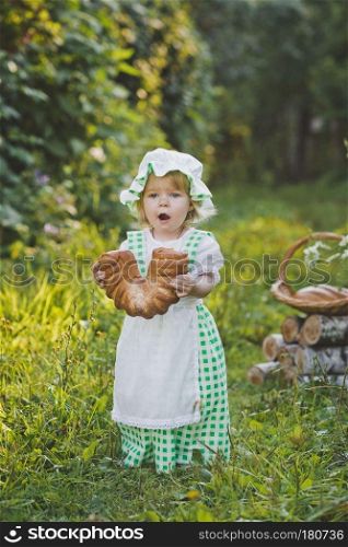 Little girl in vintage dress walking in the garden.. The child in the dress of a cook walking in the garden 4631.