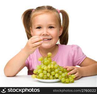 Little girl is eating grapes, isolated over white