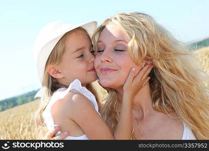 Little girl kissing her mom on the cheek