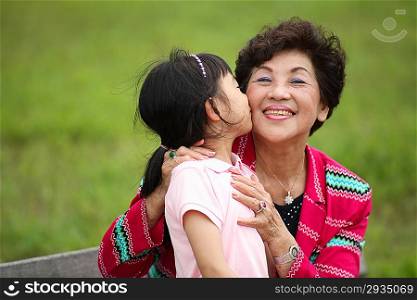 Little girl kissing senior woman