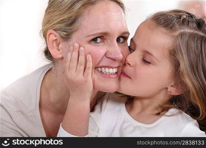 little girl kissing woman