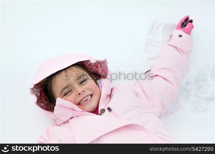 Little girl laying in the snow