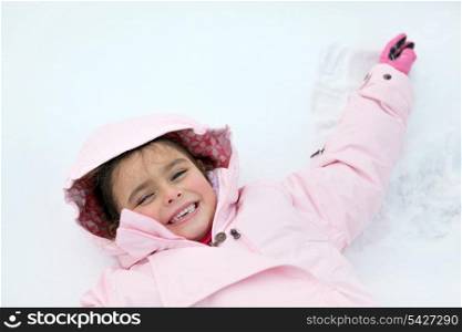 Little girl laying in the snow