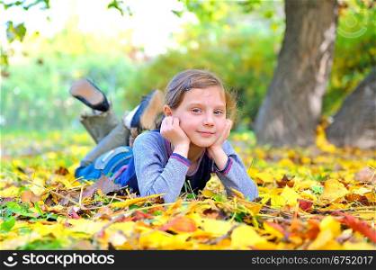 little girl lays on the leaves