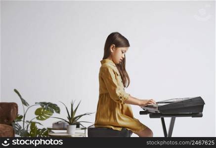 little girl learning how play electronic keyboard