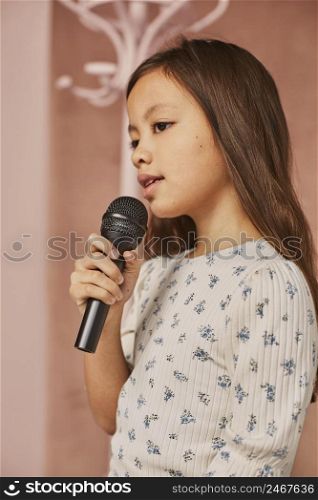 little girl learning how sing home with microphone