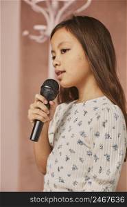 little girl learning how sing home with microphone