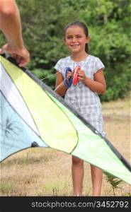 Little girl learning how to fly kite